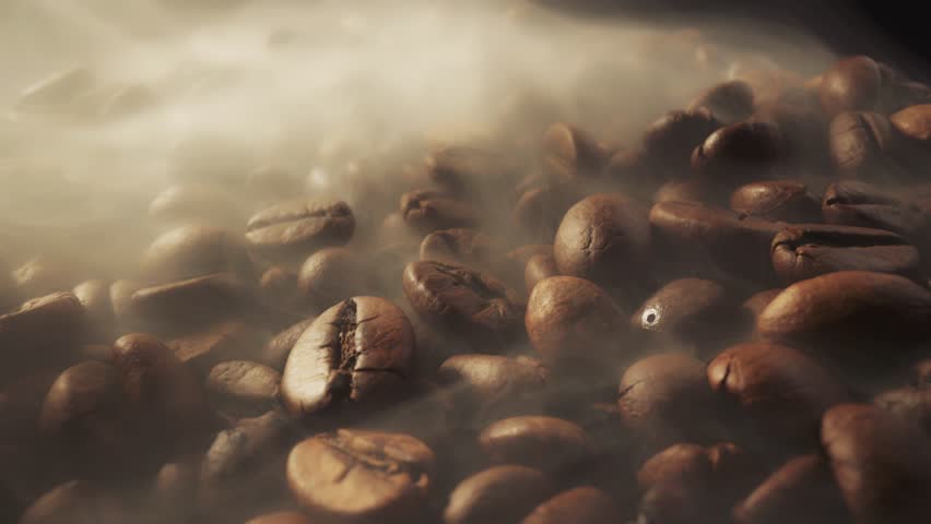 Slider shot of coffee beans during roasting. Smoke comes from fresh coffee seeds. Macro shot, 4K