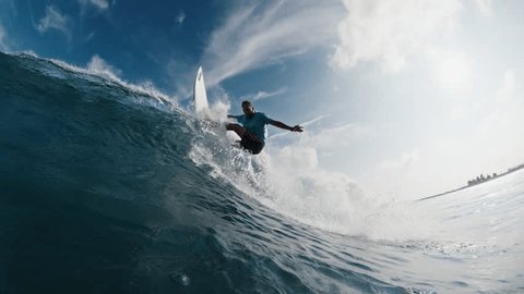 Pro surfer rides the wave, speed warp. Young man surfs the ocean wave in the Maldives and aggressively turns on the lip. Splitted above and underwater view with time warp effect: stockvideo
