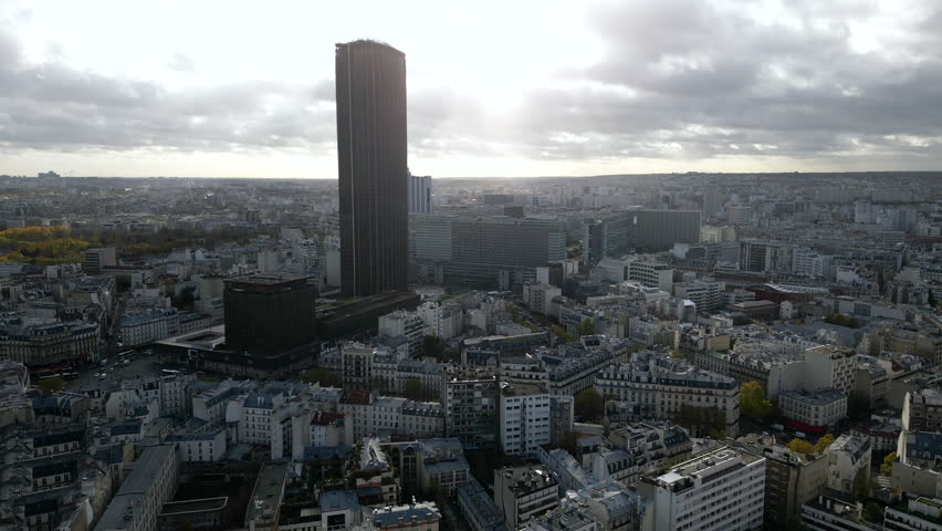 Montparnasse tower on cloudy day, Paris in France. Aerial forward