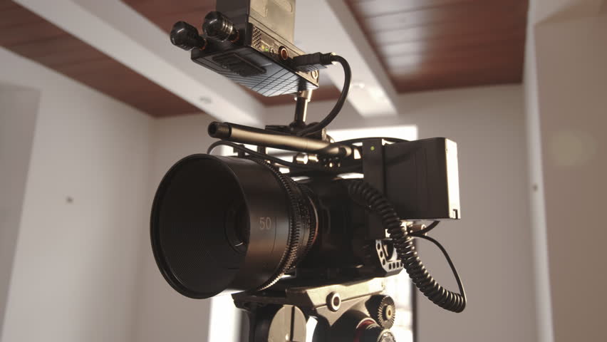 Handheld view of professional video camera on tripod indoors at daytime | Shutterstock HD Video #1100053201