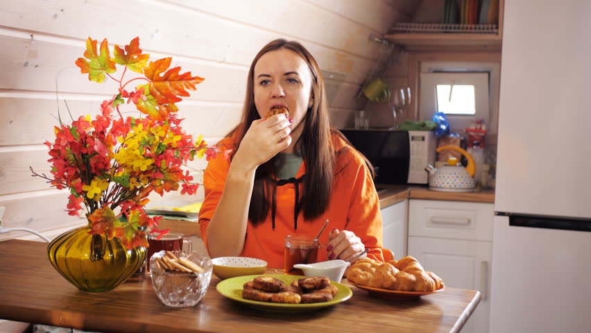 Family breakfast. The daughter hugs her mother sitting at the breakfast table.