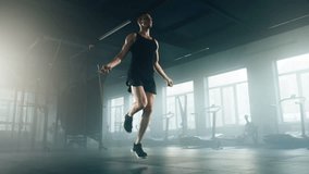Close-up view of active man using a jumping rope to improve muscle strength. Portrait of a skilled sportsman enjoying challenging exercise routine in modern gym. High quality 4k footage - Powered by Shutterstock - Get 15% off with code: PIKWIZARD15