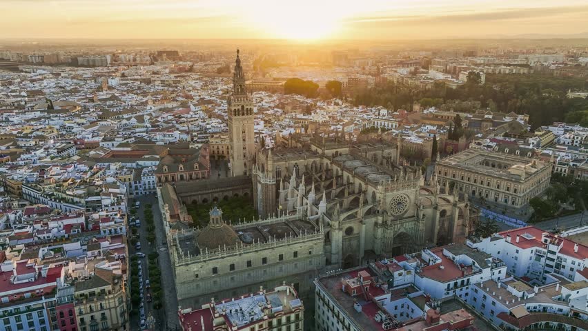 Aerial shot of Seville city center with gothic cathedral and famous Giralda bell tower. Gorgeous sunrise in Seville, Spain. UHD HDR