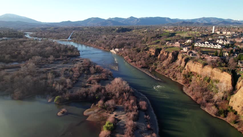 Sacramento River in Redding, California. Mountains on the horizon. 4K aerial footage.