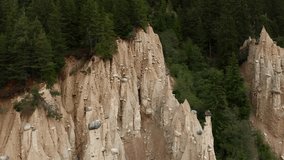 Aerial images of cliffs with shapes eroded into the earth and forests. Piramidi di perca, trentino alto, Italy.