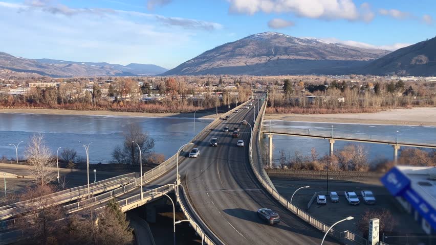 Pan Up Shot of Cars Driving Over the Overlanders Bridge in Kamloops, British Columbia on a Sunny Morning