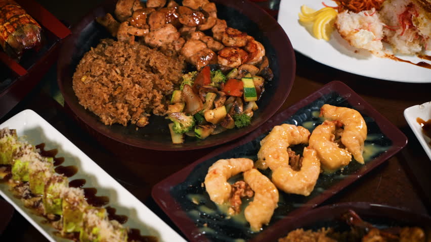 Japanese hibachi restaurant tabletop filled with variety of menu options from noodles to sushi to hibachi to tempura to gyoza, slider 4K