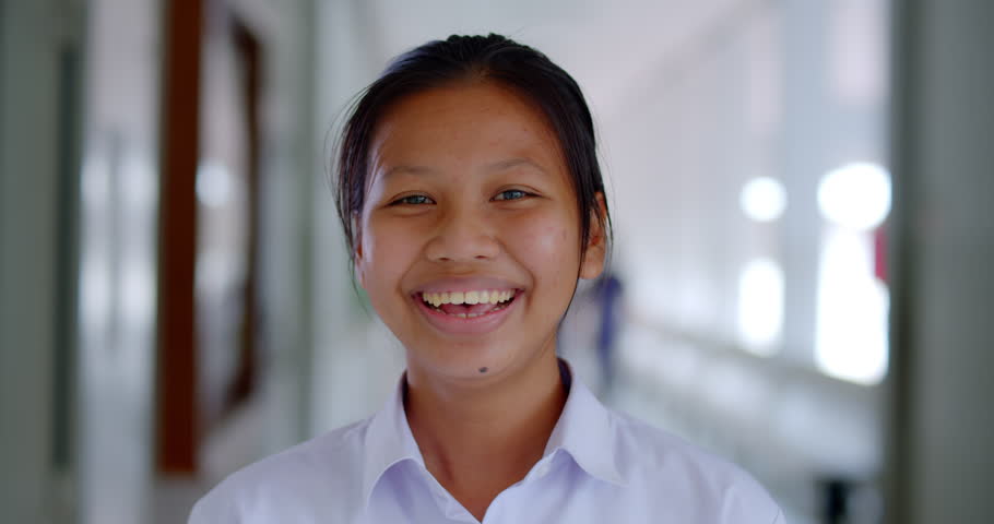 Slow motion scene of a happy smiling and laughing Asian high school student girl who is native and has acne on his face. | Shutterstock HD Video #1100066639