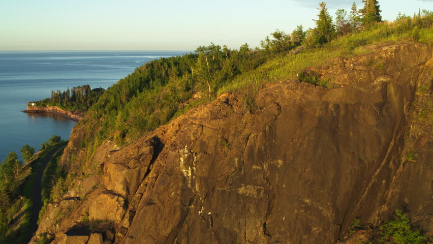 Aerial flying over forest cliff revealing Lake Superior in North America