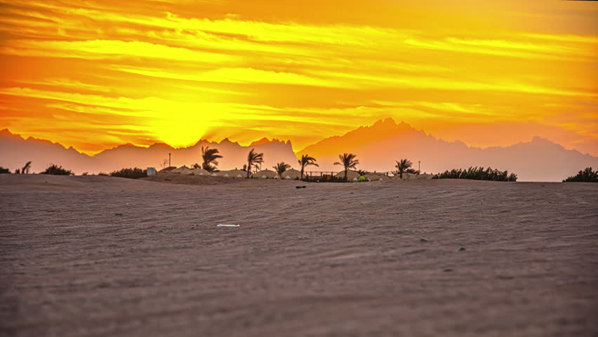 Sunrise Time lapse of a sandy desert, sun rising from behind the mountain
