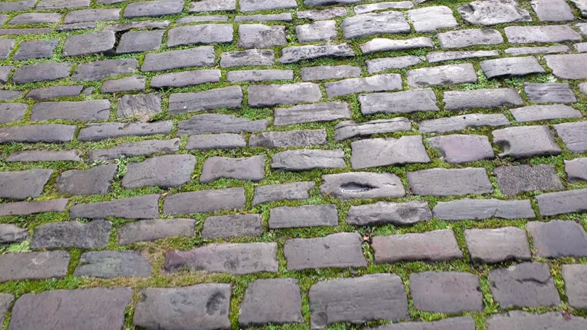 Walking along Vicar's Close, the oldest inhabited street in Europe, top down view of historic cobbled street of cobblestones in Wells, Somerset England