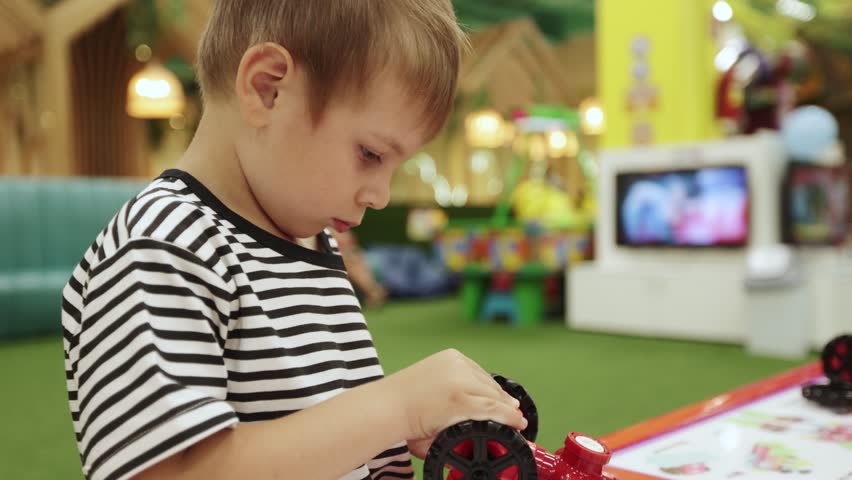A boy collects a magnetic constructor in an amusement park