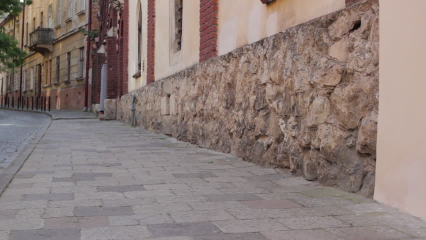 boy is running on the street,the boy runs along the old street in the city