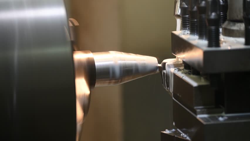 The lathe machine cutting the metal shaft parts with coolant method. The metalworking process by turning machine. | Shutterstock HD Video #1100077051