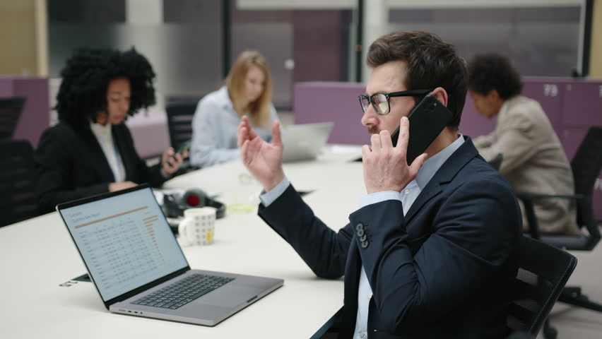 Portrait of a handsome businessman working with his colleagues in modern office space. Close-up view of sales manager calling his clients. High quality 4k footage | Shutterstock HD Video #1100078205