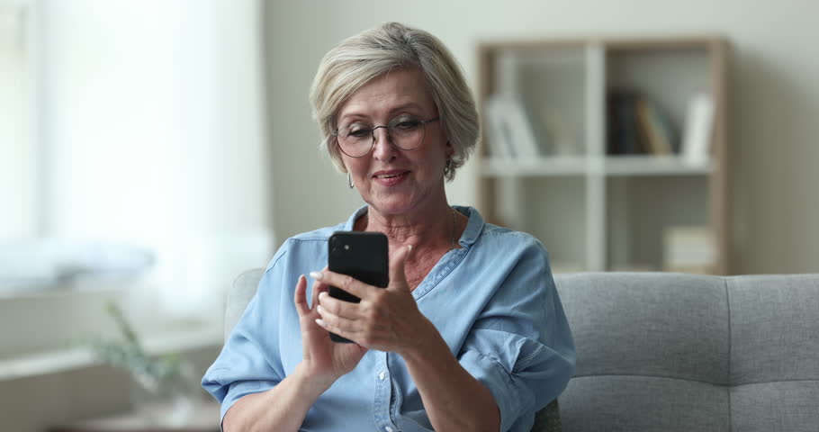 Happy senior woman read sms with good news, bank notice, message from friend looks overjoyed, enjoy great sell-out notification, auction or lottery victory, relish moment of success and achievement Royalty-Free Stock Footage #1100081187