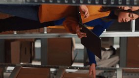 Vertical video: Depot worker looking at logistics data on laptop, working on quality control and supply chain production. Two women planning distribution, startup business development in warehouse. - Powered by Shutterstock - Get 15% off with code: PIKWIZARD15