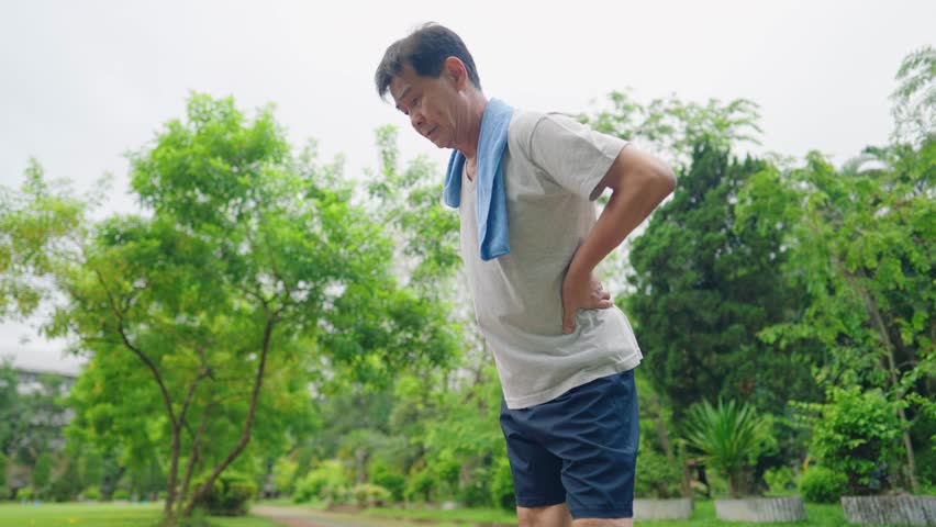 Senior asian man doing hip and waist cool down exercise, preventing lower back pain injury from workout, office syndrome remedy, stretching body trunk and mid body muscles for stronger core. Royalty-Free Stock Footage #1100085111