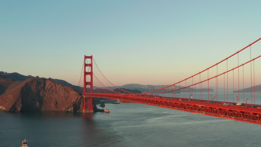 Dolly back revealing aerial shot of the golden gate bridge at sunset Royalty-Free Stock Footage #1100086245