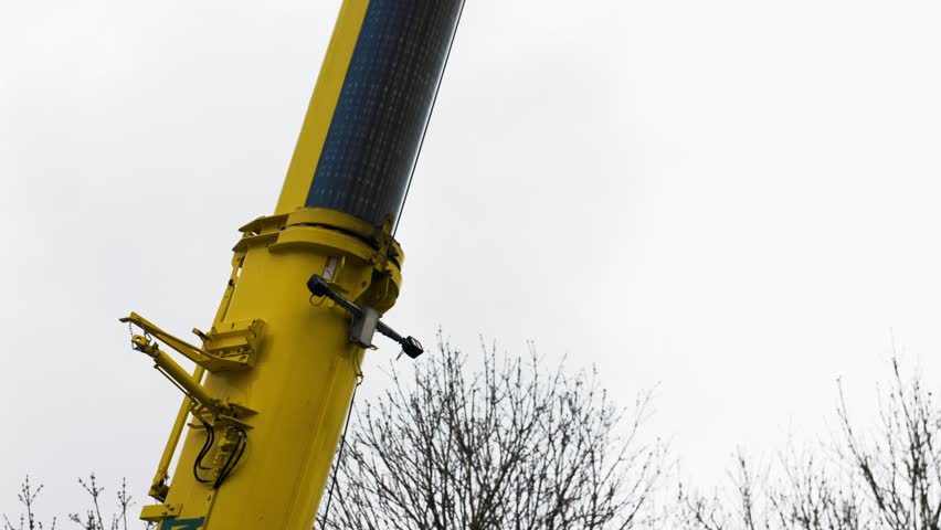 Yellow pipe crane working on construction