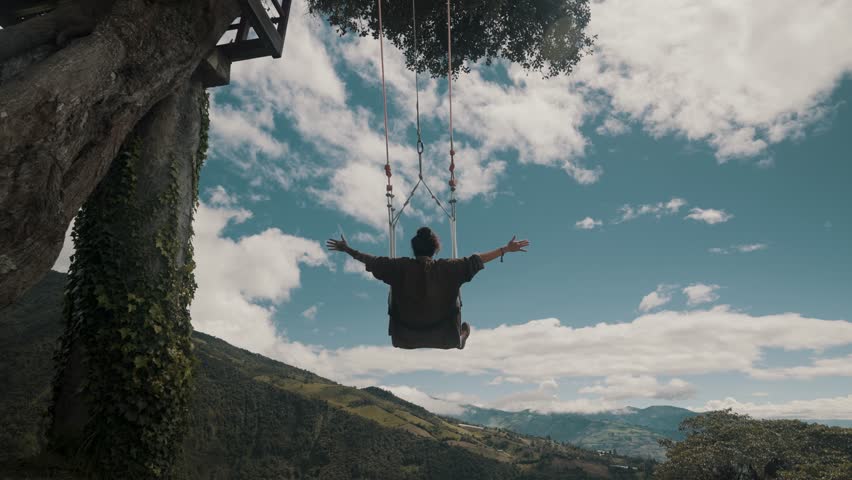 A Tourist Riding The Famous Swing At The End Of The World During Summertime In Banos, Ecuador. Handheld