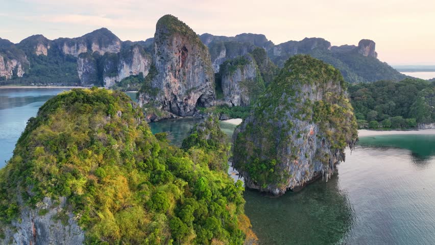 Aerial view of iconic tropical Railay beach in Thailand, beautiful limestone cliffs of idyllic Thailand Ao Nang beach. Paradise Krabi resort with scenic rock formation. Thai holiday destination Royalty-Free Stock Footage #1100095533