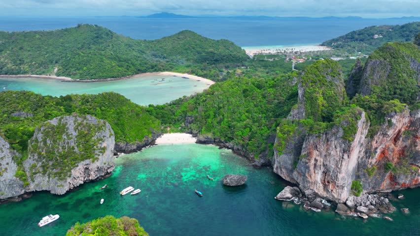 Paradise tropical island of Koh Phi Phi in Thailand, aerial view of exotic lagoon of Nui beach on Koh Phi Phi, idyllic vacation in the tropics, tourism in Thailand. High quality 4k footage | Shutterstock HD Video #1100095535