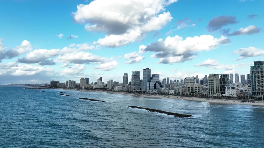 Aerial view of Tel Aviv coastline , on the background of city skyline high rise buildings and hotels.
