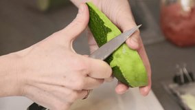 A woman cleans avocados in the kitchen. Vegan breakfast snack. Video in slow motion.