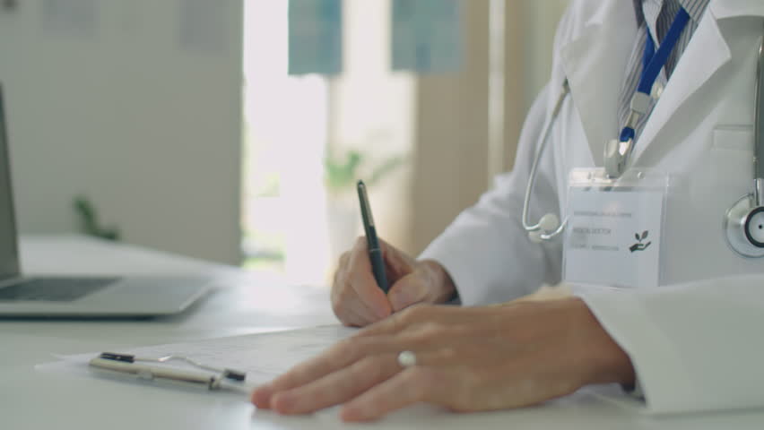 Close up shot of male patient and doctor signing medical agreement during consultation in clinic | Shutterstock HD Video #1100101993