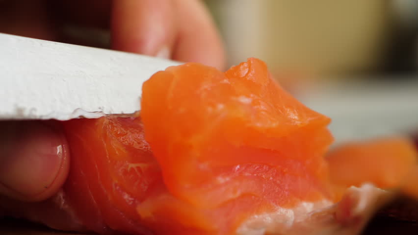 Healthy Eating Sea Food Omega. Man Cutting Red Fish Salmon On Wooden Board Close Up. Chef Cuts Redfish, Most Delicious Meat Slow Motion. Macro Chef Cuts Salmon Fillet Slices For Cooking Sushi Closeup.
