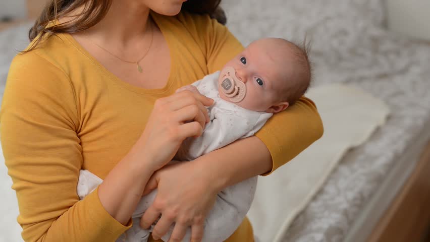 Mother holding baby and kissing her  | Shutterstock HD Video #1100105953