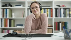 Young beautiful hispanic woman student having video call sitting on table at library university