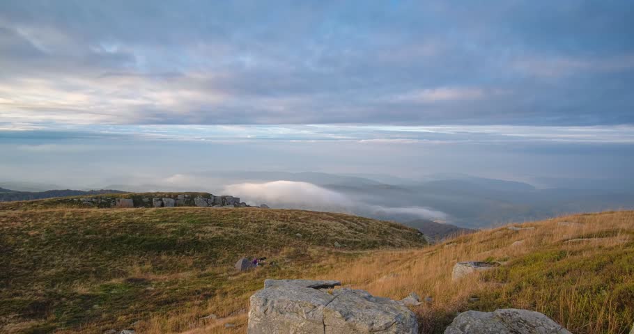 Two tourists roll up tent against the backdrop of a beautiful morning mountain landscape. Beautiful and funny time lapse