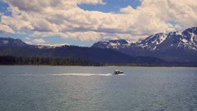 Fast sailing boat on the water of Lake Tahoe with Sierra Nevada Mountains in the background. 4K UHD video.
