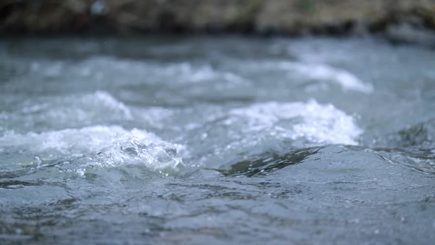 Water flowing in a river. A fast flowing stream