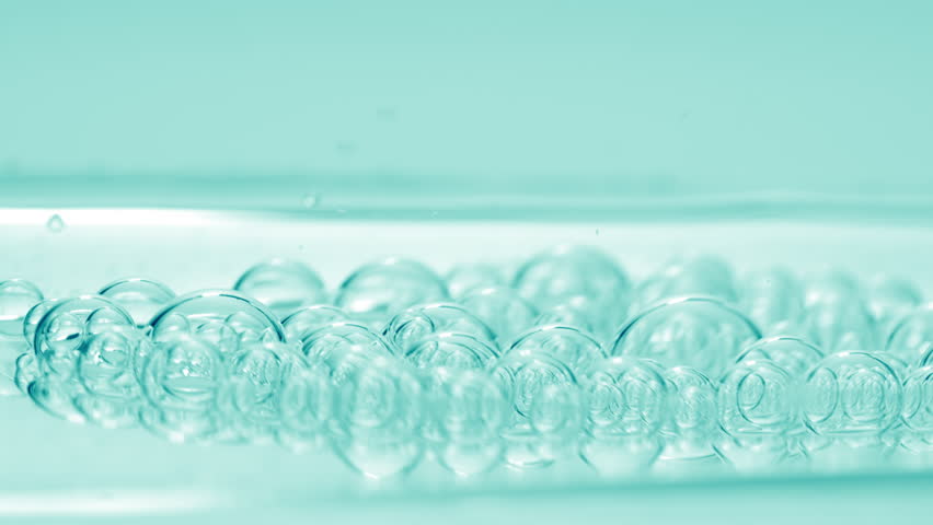 Shot of cyan transparent bubbles of hyaluronic acid sink to the fluid surface with another ones on cyan background | Abstract anti-aging cosmetics with hyaluronic acid formulation concept | Shutterstock HD Video #1100119015