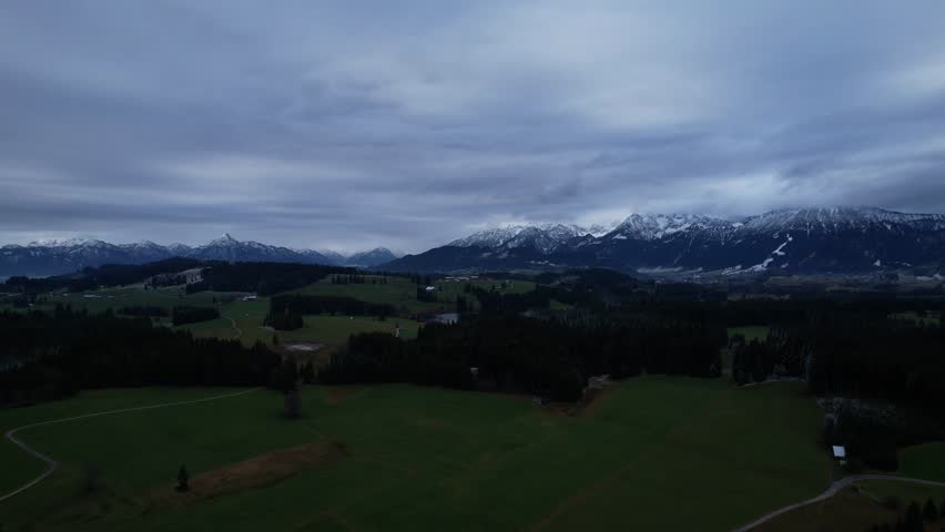 DRONE AERIAL FOOTAGE: Winter view from the Allgau Alps mountain range in the Northern Limestone Alps and alpine lake Attlesee, located near Nesselwang town, Bavaria, Germany.