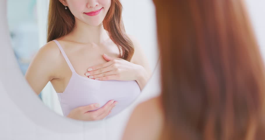 breast cancer self check concept - slow motion of asian woman is touching her chest to prevent sick while looking in mirror at home Royalty-Free Stock Footage #1100122949