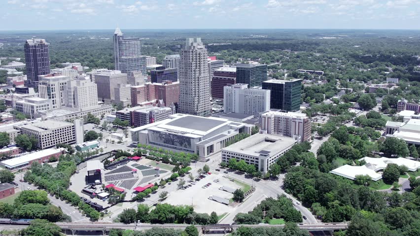 High aerial tilt down shot of Raleigh skyline in North Carolina. Establishing shot from drone on sunny summer day.
