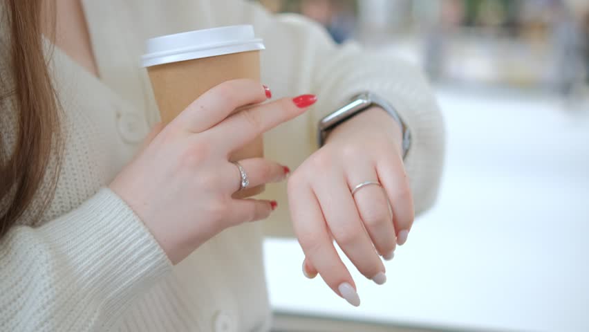 Womans hand touching a smart watch. Smart watch on a womans hand indoor