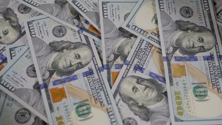 Close-up of a lot of hundred-dollar bills slowly rotating. Financial concept. Background of US dollar bills.
