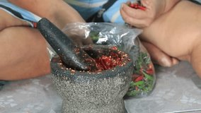 Hand-pounding chili and garlic in a granite mortar is a combination of stir-fried basil and dipping sauce - a traditional hand-crafted Thai food that adds more flavor to the delicious food.
