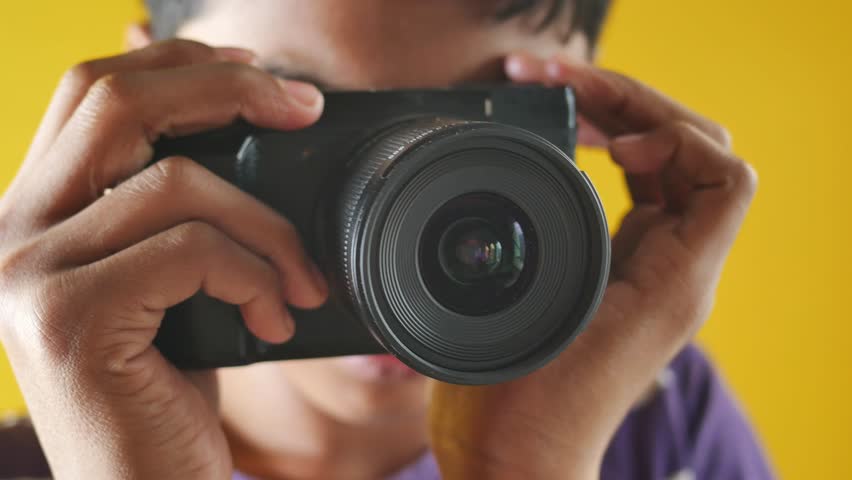 a boy takes pictures toward the camera.