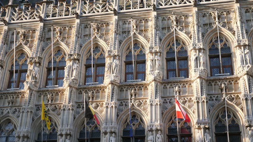 Closeup of lace-like sculptural details and statues on facade of gothic Leuven Town Hall building. Famous Belgian landmark. High quality 4k footage