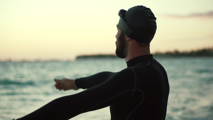 Swimmer Silhouette Training Triathlon In Open Water. Swimmer Stretching Exercise In Ocean.Professional Triathlete Prepare Swimming Workout Sport Recreation. Triathlete Ready Triathlon Competition Swim Royalty-Free Stock Footage #1100129227