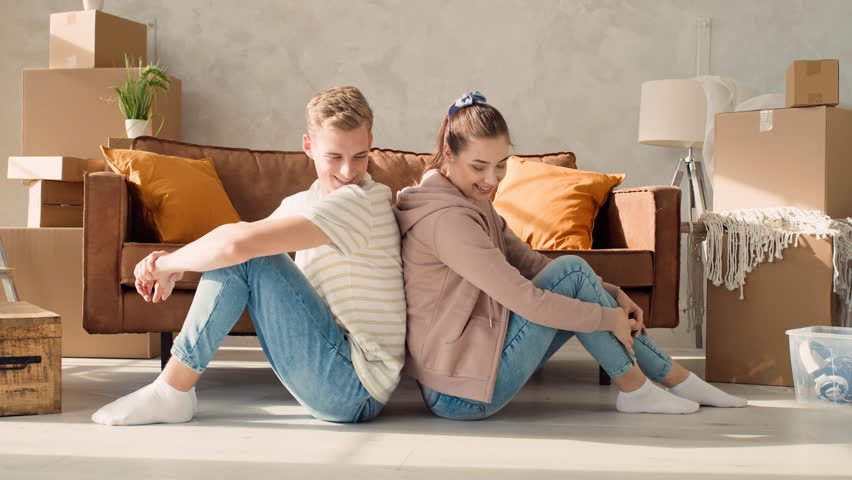 Couple Sitting Back to Back in a New Home. Couple Moving to a new House. Shot on RED. | Shutterstock HD Video #1100129337