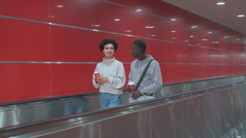 Couple of students walking to the subway escalator. public place. | Shutterstock HD Video #1100130901