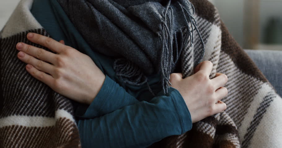 Close up of the young unwell caucasian woman in the warm scarf and a plaid shivering as she having a high temperature. At home. Inside Royalty-Free Stock Footage #1100135463