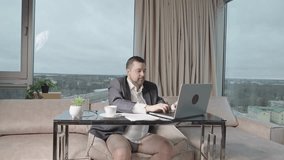 Man in suit without pants working online. home office, video conference, self-isolation concept. Businessman working at home. Remote work, work on the Internet, remotely